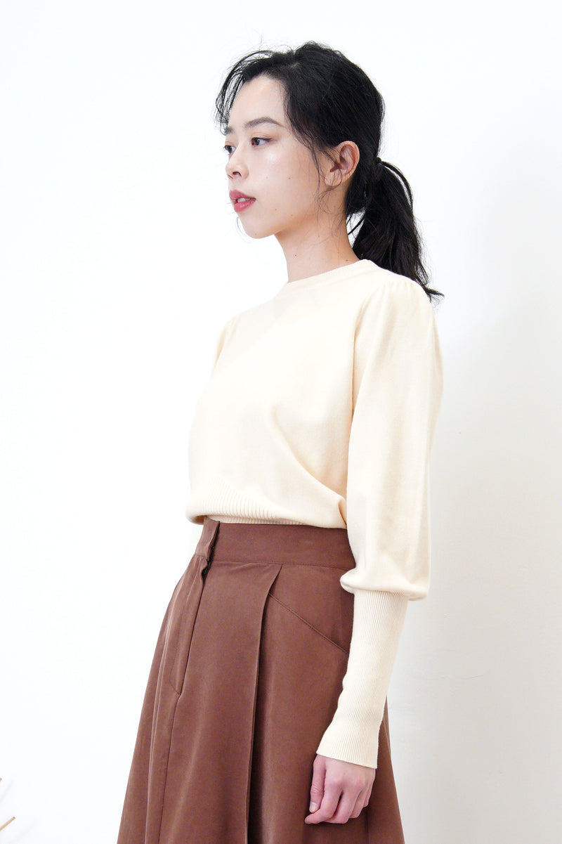 Cream knit top in detail sleeves cutting