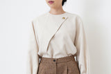 Nude satin blouse in asymmetrical cutting