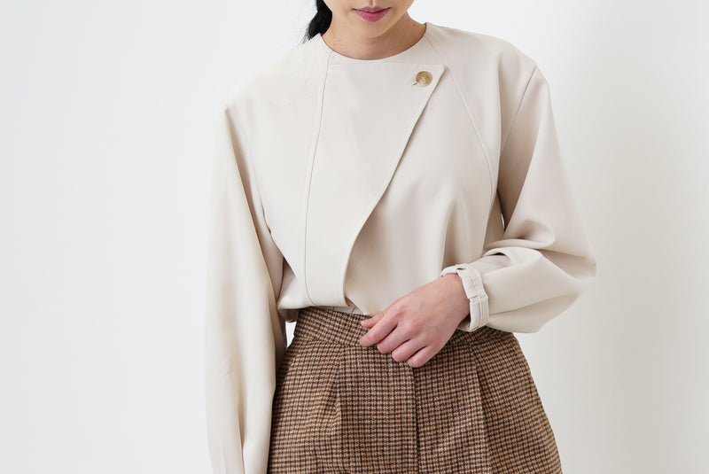Nude satin blouse in asymmetrical cutting